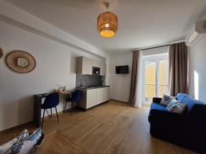 a living room with a blue couch and a kitchen at Domus Nova - Luxury Residence in Pizzo