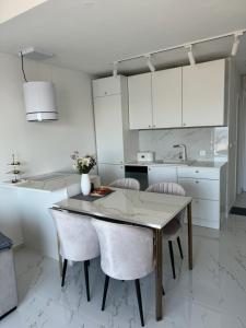 a kitchen with a dining room table and chairs at Perla in Stinica