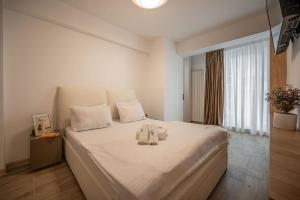 a bedroom with a bed with two towels on it at Lotti in Infinity Pool & Spa Resort in Mamaia