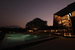 a building with a swimming pool at night at The Deck in Junagadh +30 photos