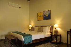 a bedroom with a bed with two tables and two lamps at The Deck in Junagadh