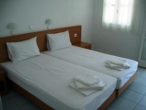 ein großes weißes Bett mit zwei Handtüchern darauf in der Unterkunft Kleopatra's Rooms in Livadia