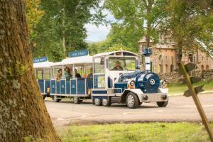 ein kleiner blau-weißer Zug fährt eine Straße entlang in der Unterkunft Crieff Hydro in Crieff