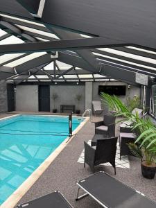 a large swimming pool with chairs and a swimming pool at Magnificent Country House with Swimming Pool in Barmouth +63 photos