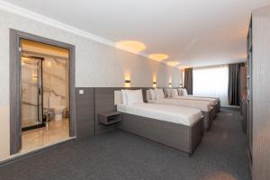 a hotel room with two beds and a window at Istanbul By Rich Hotel in Istanbul +12 photos