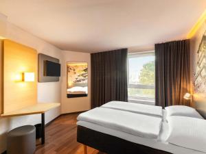 a hotel room with a bed and a window at B&B Hotel Düsseldorf-Hbf in Düsseldorf