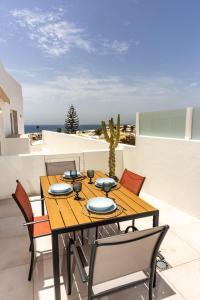 a wooden table and chairs on a balcony with the ocean at Luxury Beach La Concha Playa Honda in Playa Honda