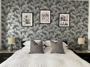 a bedroom with a bed with three pictures on the wall at HOMES By PALUMBO in Prunella