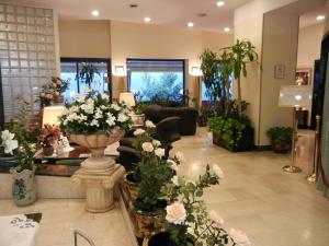 a lobby with flowers and plants in a store at Delle Nazioni Milan Hotel in Milan