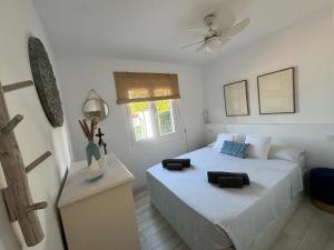 Un dormitorio con una cama y un ventilador de techo. en Apartamento con jardín privado en Menorca, en Cala'n Porter 38 fotos más