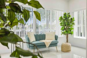 a living room with a blue couch and a plant at Modern 4BR Retreat with Private Pool - Near Brickell in Miami +53 photos