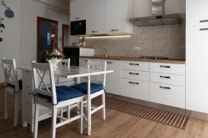 a kitchen with white cabinets and a table and chairs at Dormen in Guspini
