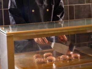 a man is cooking donuts in a oven at Yamanaka Onsen Kajikaso in Kaga +186 photos