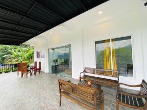 ein Raum mit Bänken, Tischen und Fenstern in der Unterkunft TK Homes in Badulla