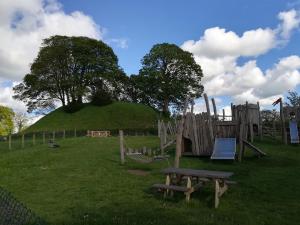 a playground with a hill with a picnic table and a bench at Acer Cottage in Bampton