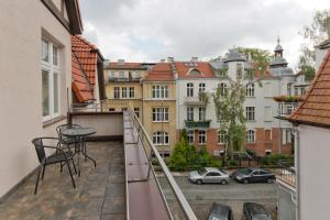 a balcony with a table and chairs and buildings at Imperial Apartments - Moderna in Sopot