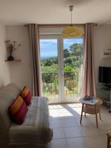 a living room with a couch and a large window at Villa Nassalia in Lorgues