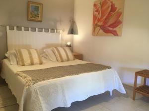 a bedroom with a white bed with a painting on the wall at Villa Nassalia in Lorgues +18 photos