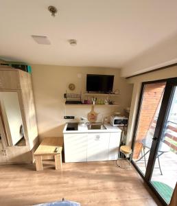 a kitchen with a sink and a tv on the wall at Mountain View Apartment Near Ski Slopes Gudauri in Kʼumlistsʼikhe