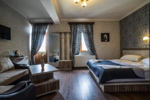 una camera da letto con un letto e un divano di Hotel Tiflis a Akhaltsikhe