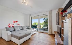 a living room with a white couch and a tv at Ferienwohnung Pörtschach 90M² in Pörtschach am Wörthersee +18 photos