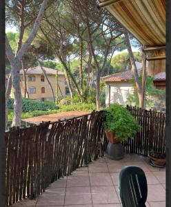a wooden fence with a potted plant on a patio at Puccini 200 mt dal mare con parking in Castiglione della Pescaia
