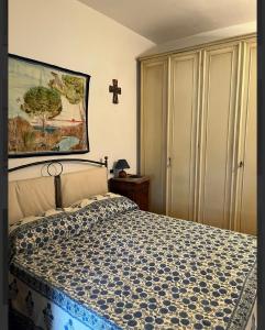 a bedroom with a bed with a cross on the wall at Puccini 200 mt dal mare con parking in Castiglione della Pescaia