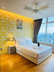 a bedroom with a large bed with a yellow wall at Vortex Suites KLCC by Nadia in Kuala Lumpur