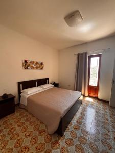 une chambre avec un grand lit et une fenêtre dans l'établissement La Dimora Sicula, à Modica 17 autres photos