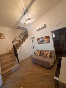 un salon avec un canapé et un escalier dans l'établissement La Dimora Sicula, à Modica