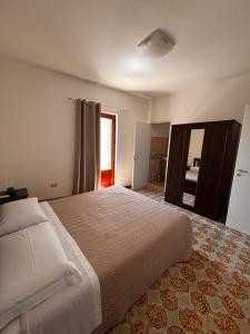 une chambre avec un grand lit et une fenêtre dans l'établissement La Dimora Sicula, à Modica