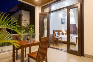 a room with a dining table and a bedroom at Hoi An Sun Lake Villa in Hoi An