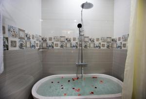 a bathroom with a bath tub with red flowers in it at Hoi An Sun Lake Villa in Hoi An +44 photos