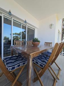 un tavolo in legno con sedie e una pianta in vaso. di Frente al Mar Primera Linea de Playa Samil a Vigo