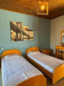 two twin beds in a room with a bridge picture on the wall at KIRKOS “PORTO” in Samothraki
