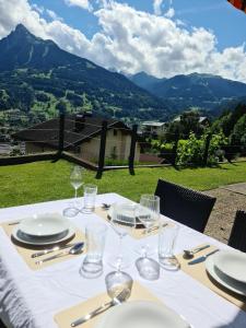 a table with plates and glasses and a view of mountains at Haus Hermann in Schruns-Tschagguns