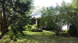 ein Haus mit einem Garten mit Bäumen davor in der Unterkunft Villa Gården in Vidsel