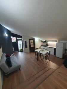 a living room with a table and a couch at MD Apartament- Cazare la curte in Curtea de Argeş +14 photos