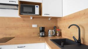 a kitchen with a sink and a microwave at VacationClub - Lotnicza 1L Apartament 44 in Sianozety
