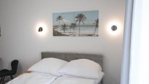 a bedroom with a bed with palm trees on the wall at VacationClub - Lotnicza 1L Apartament 44 in Sianozety