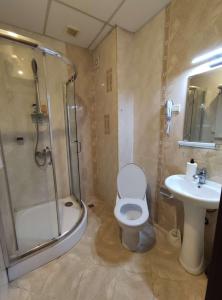 a bathroom with a shower and a toilet and a sink at Beachfront apartment in 4star Hotel - Kiten in Kiten