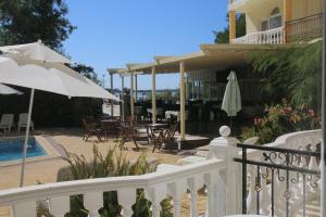 a balcony with a pool and chairs and an umbrella at Beachfront apartment in 4star Hotel - Kiten in Kiten