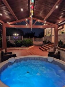 Un gran jacuzzi en un patio con techo de madera. en Villa Daisy Conversano-Polignano a Mare, en Conversano