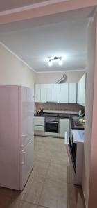 a kitchen with white cabinets and a white refrigerator at Sea Side in Herceg-Novi