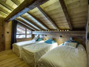 deux lits dans une chambre avec plafonds en bois dans l'établissement Chalet luxueux 4****, calme, proche pistes ski, 10 pers, WiFi, parking - FR-1-304-196, à La Clusaz