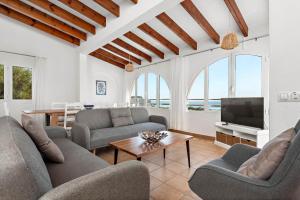 ein Wohnzimmer mit zwei Sofas und einem Fernseher in der Unterkunft Villa Esplendor in Son Bou