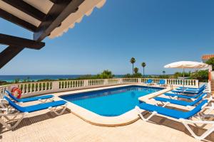 einen Pool mit Liegestühlen und einem Sonnenschirm in der Unterkunft Villa Esplendor in Son Bou