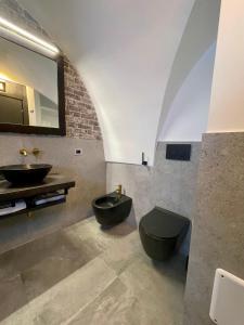 a bathroom with a black toilet and a sink at Calliope in Gallipoli +28 photos