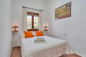 a bedroom with a bed with orange pillows and a window at Casa Torre del Manzano in Torrox +25 photos