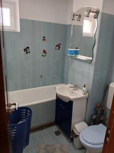 Un baño con lavabo, inodoro y espejo. en Apartament cu 2 camere, en Călimăneşti